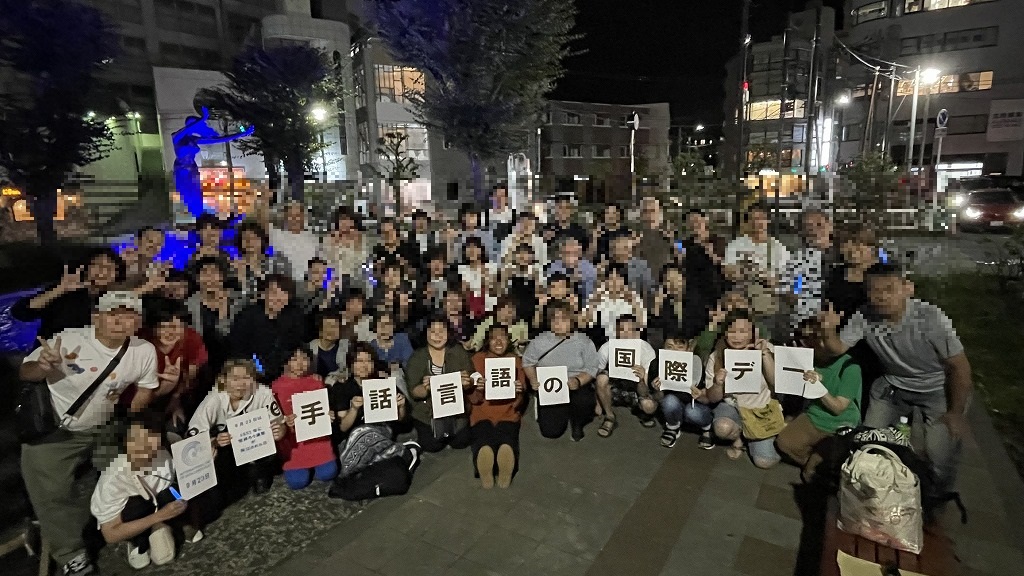 横断幕を掲げて記念撮影